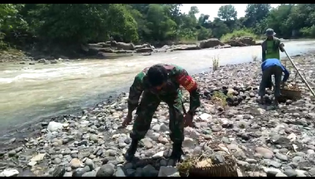 Gunakan Alat Angkut "Pikulan" Serda Beni Membawa Batu Kali Sebagai Material Makadam Jalan